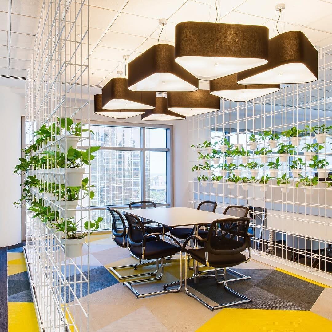 Dining area with a planted wall and sculptural pendant